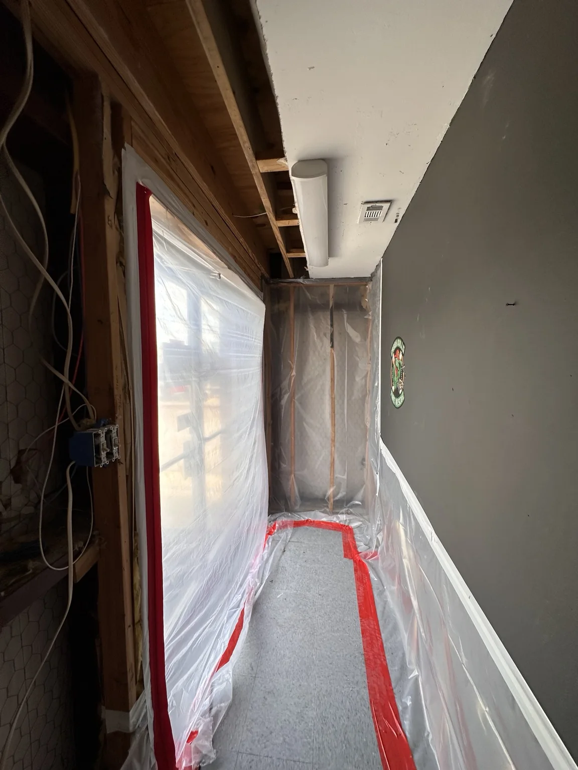 Protected corridor with temporary plastic and taped floor edge in fire station