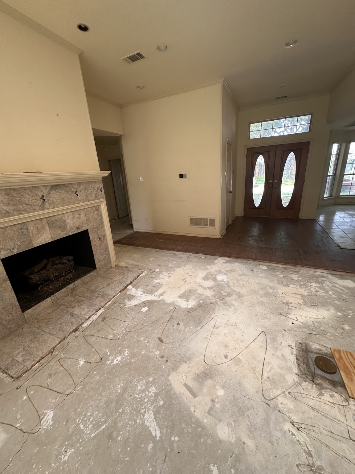 Exposed slab near fireplace after flooring removal.