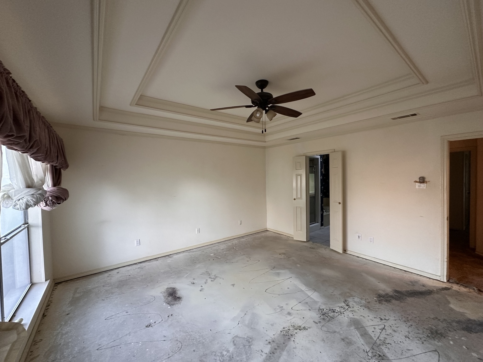Large room with slab exposed after carpet and pad removal.